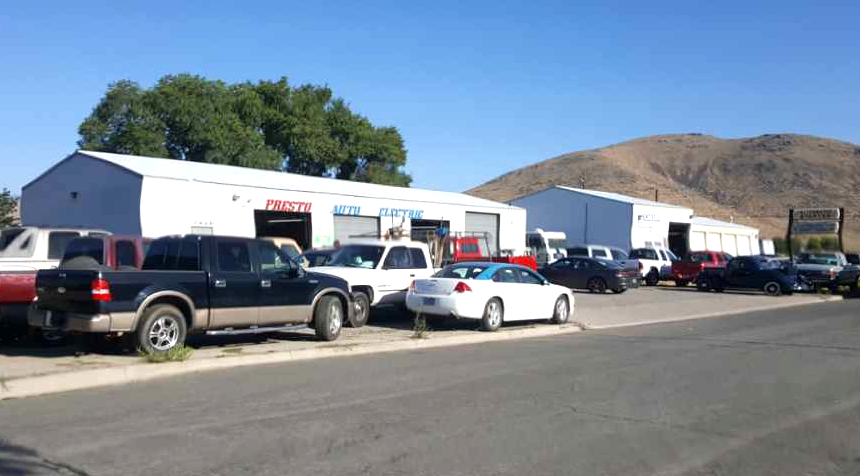 A lot of cars are parked in front of a garage