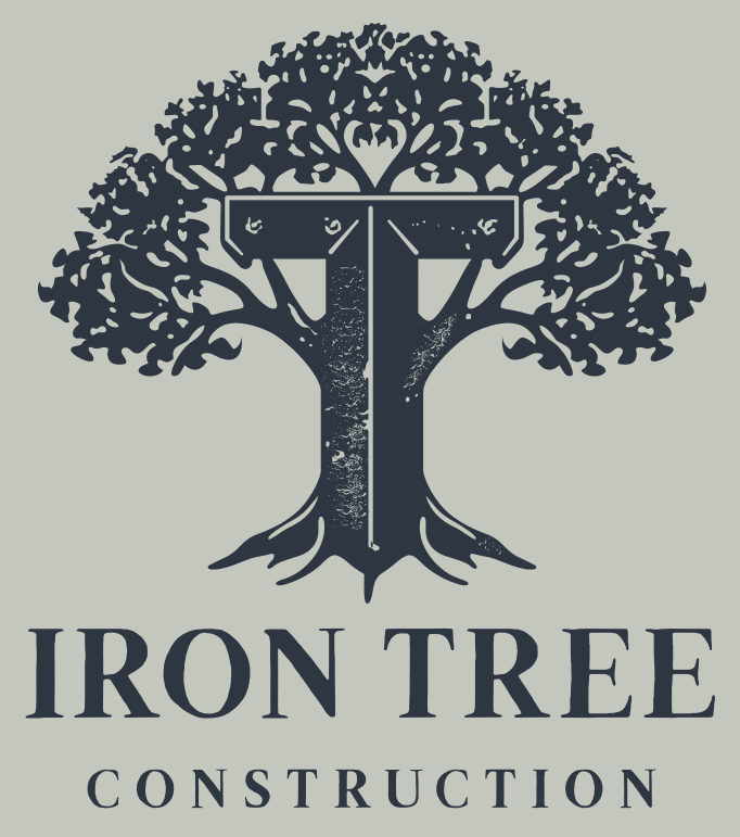 Logo for Iron Tree Construction featuring a dark blue stylized tree in the shape of a letter T on a light gray background.