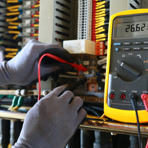 A person is using a multimeter to measure voltage