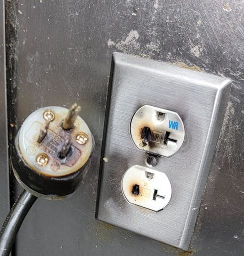 A damaged electrical outlet has the word on it