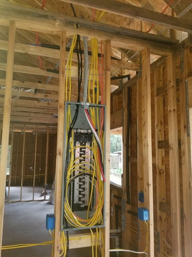 A person is working on an electrical box with a screwdriver.