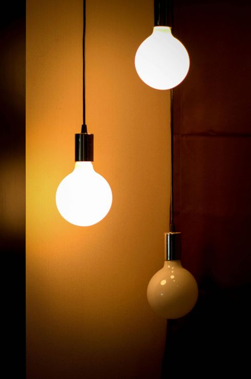 Two light bulbs are hanging from the ceiling in a dark room.