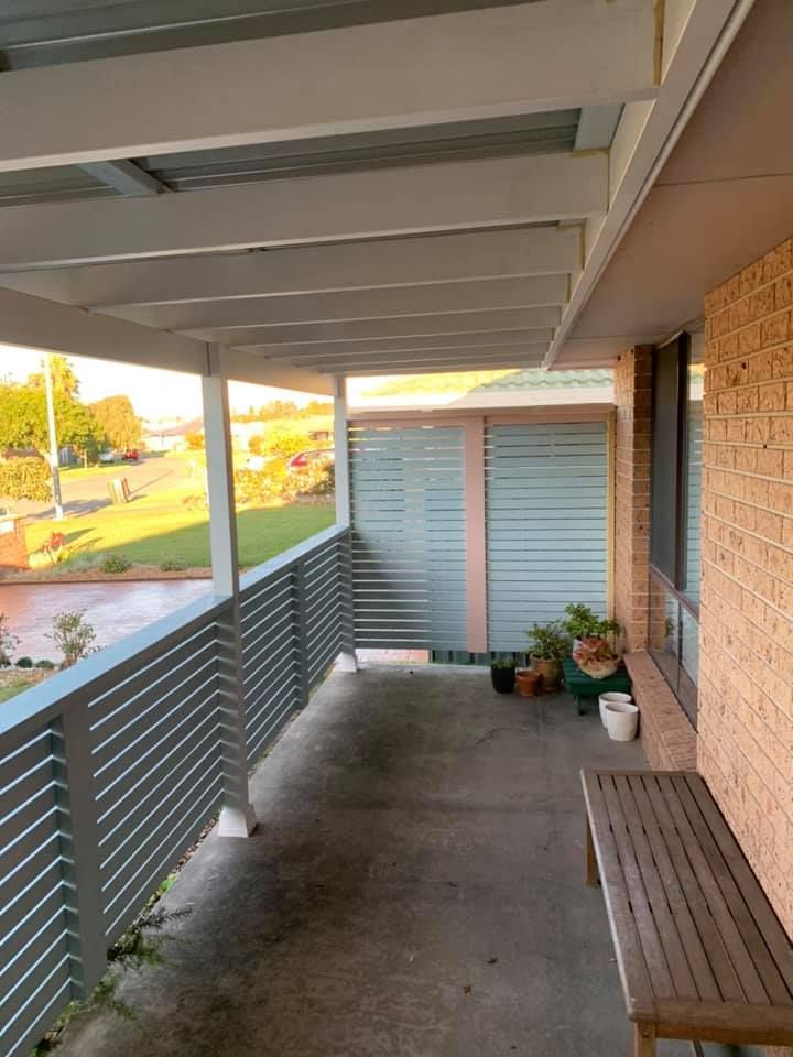 A Balcony With a Bench and Potted Plants on It — Portstyle Constructions in Robina, QLD