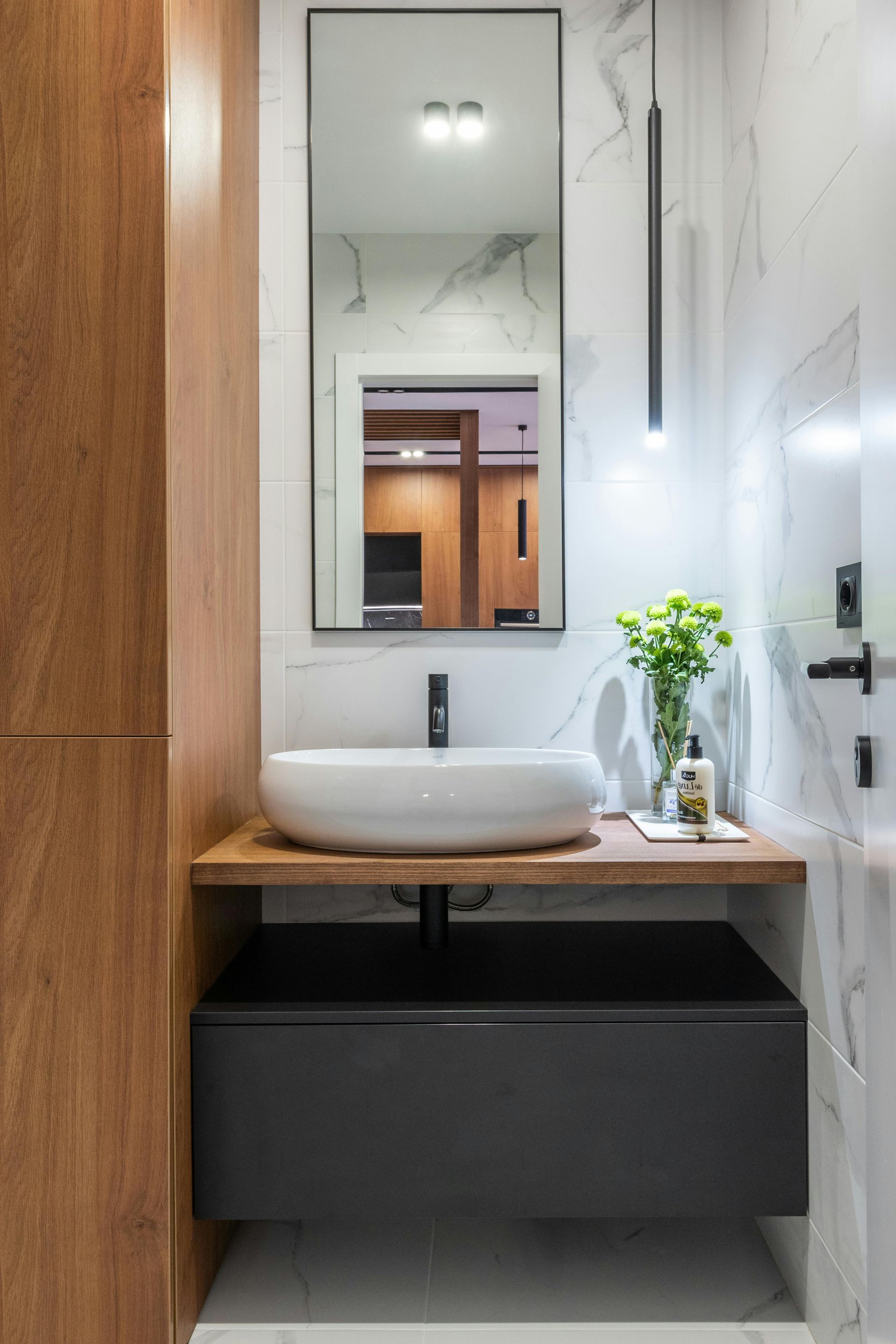 A Bathroom With Funky Tiles and Round Mirror— Portstyle Constructions in Robina, QLD
