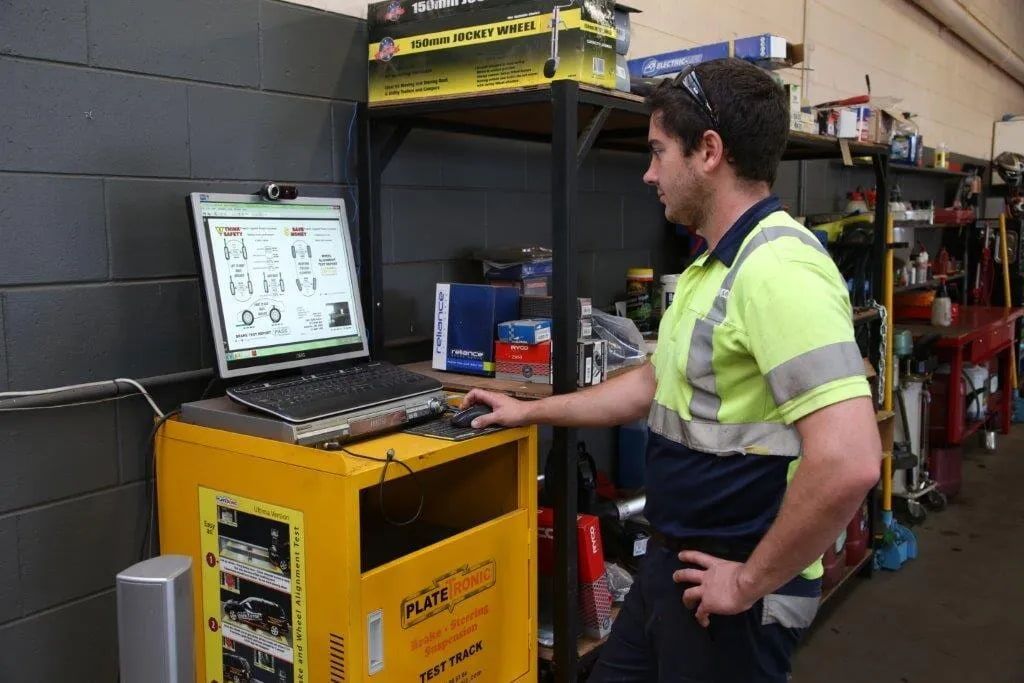A Man Is Standing In Front Of A Computer In A Garage — Cam Duffy Autos In Atherton, QLD
