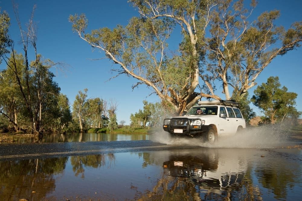 A White Suv Is Driving Through A Flooded Road — Cam Duffy Autos In Atherton, QLD