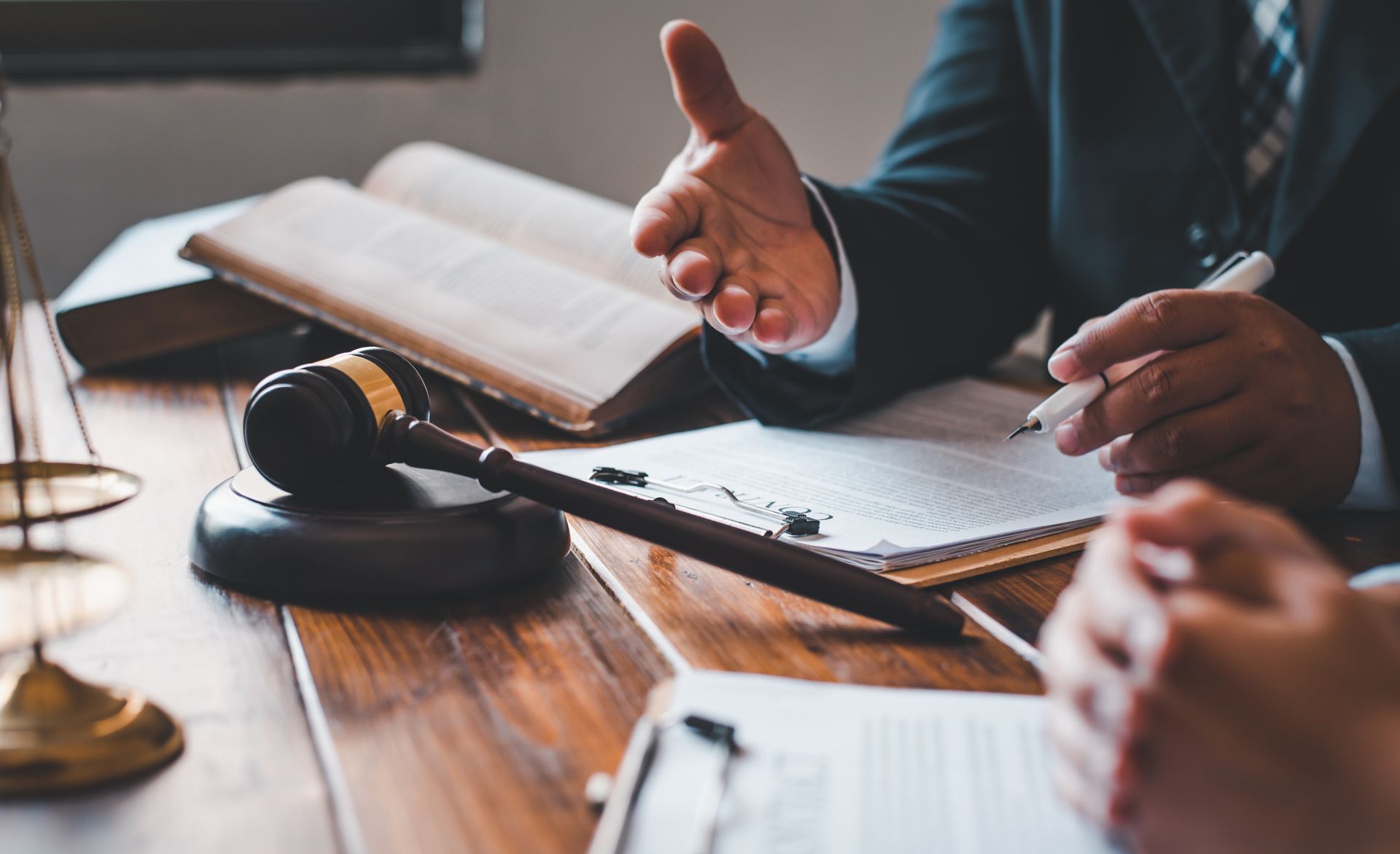 A judge is sitting at a wooden table talking to a client.