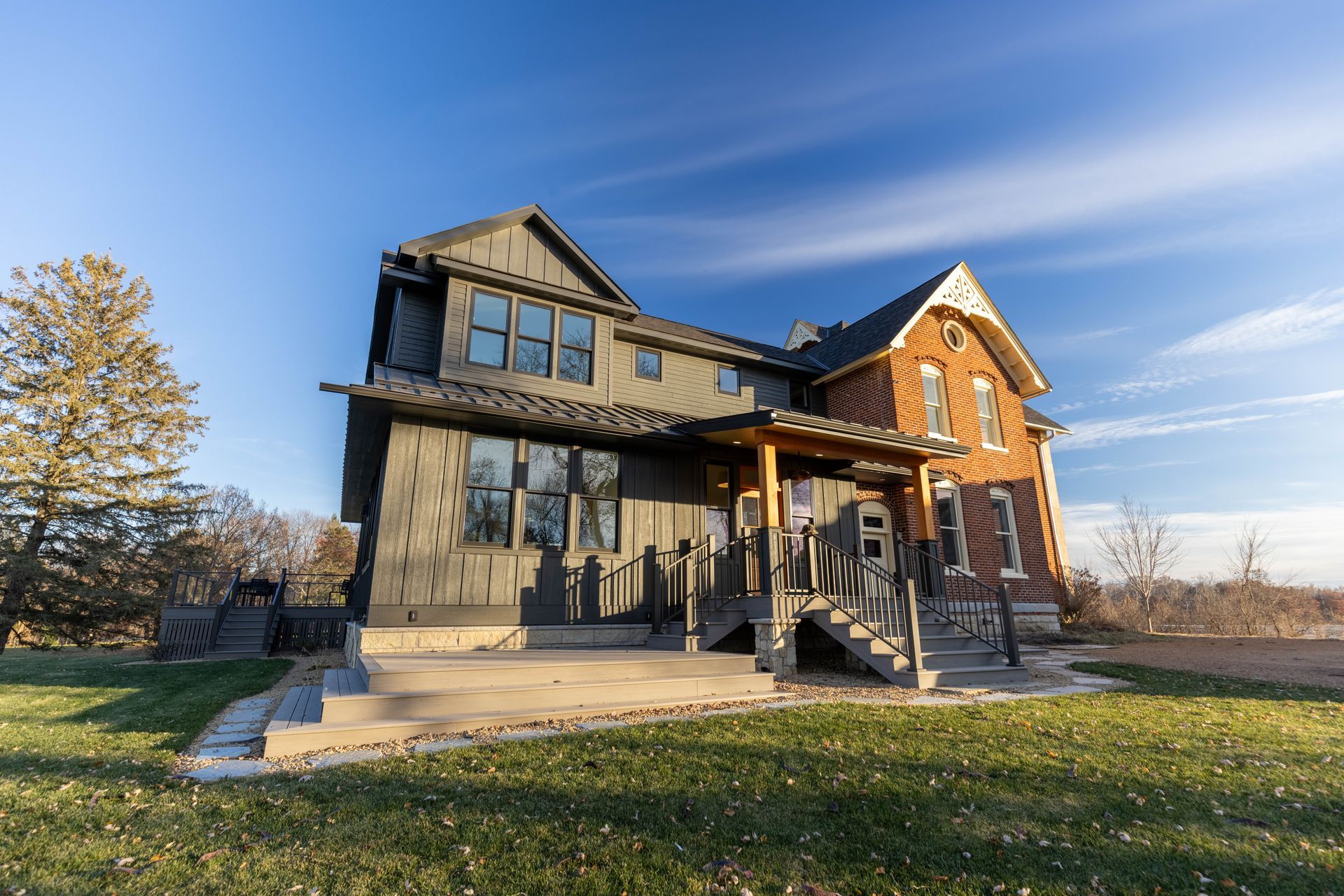 A large house is sitting on top of a lush green field.