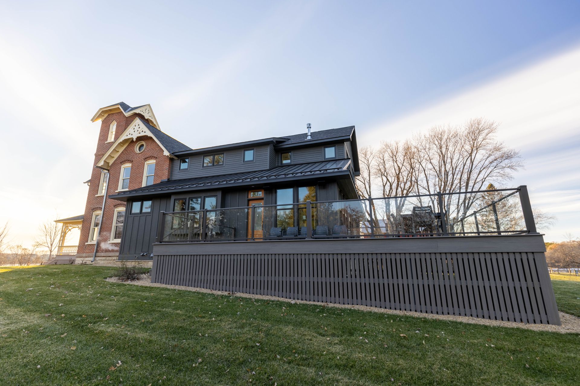 A large brick house with a large deck in front of it.