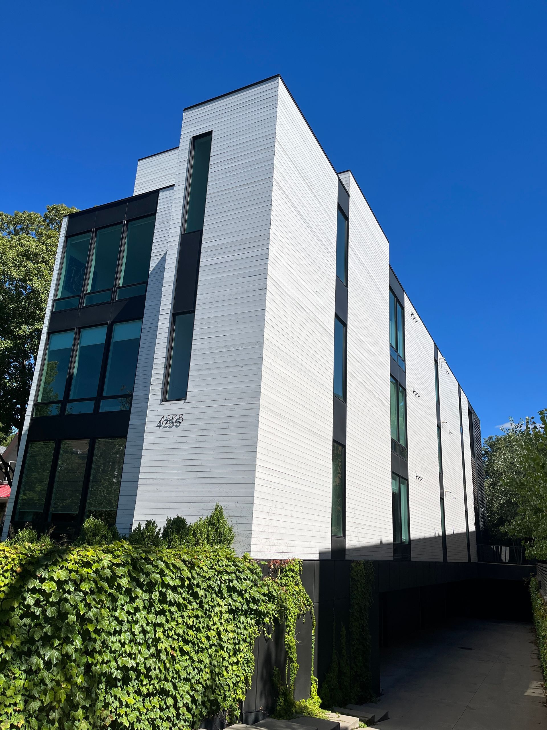 A large white building with lots of windows and a blue sky in the background