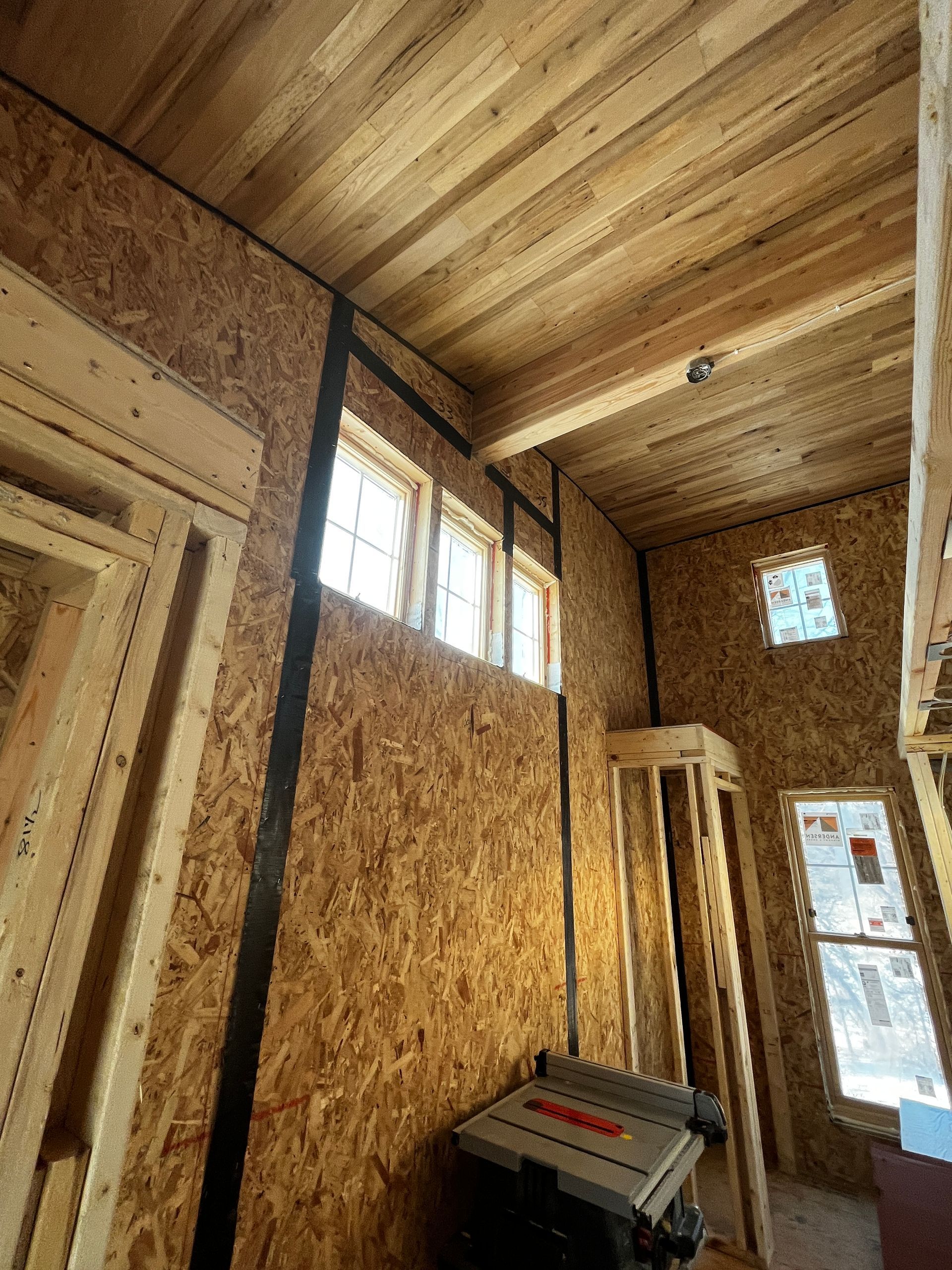 A room with a wooden ceiling and a table in it.