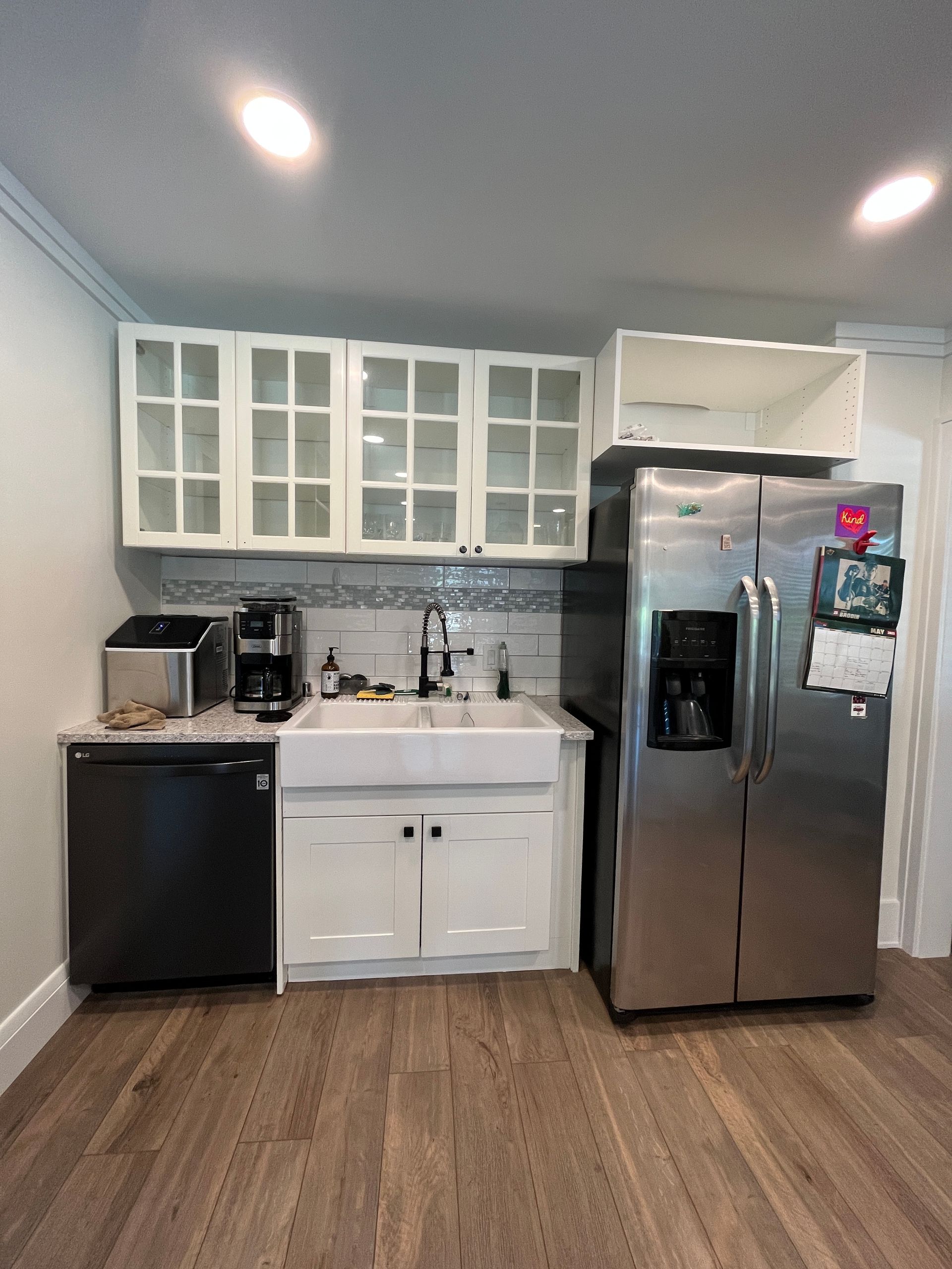 A kitchen with a stainless steel refrigerator , sink , and dishwasher.