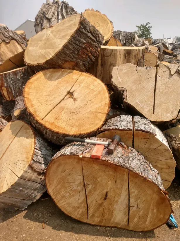 A pile of logs with a screwdriver on top of them.