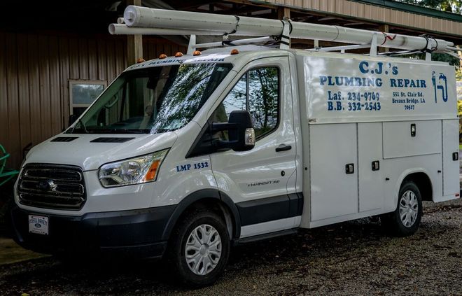 White utility service van parked indoors, with side compartments and blue company lettering.