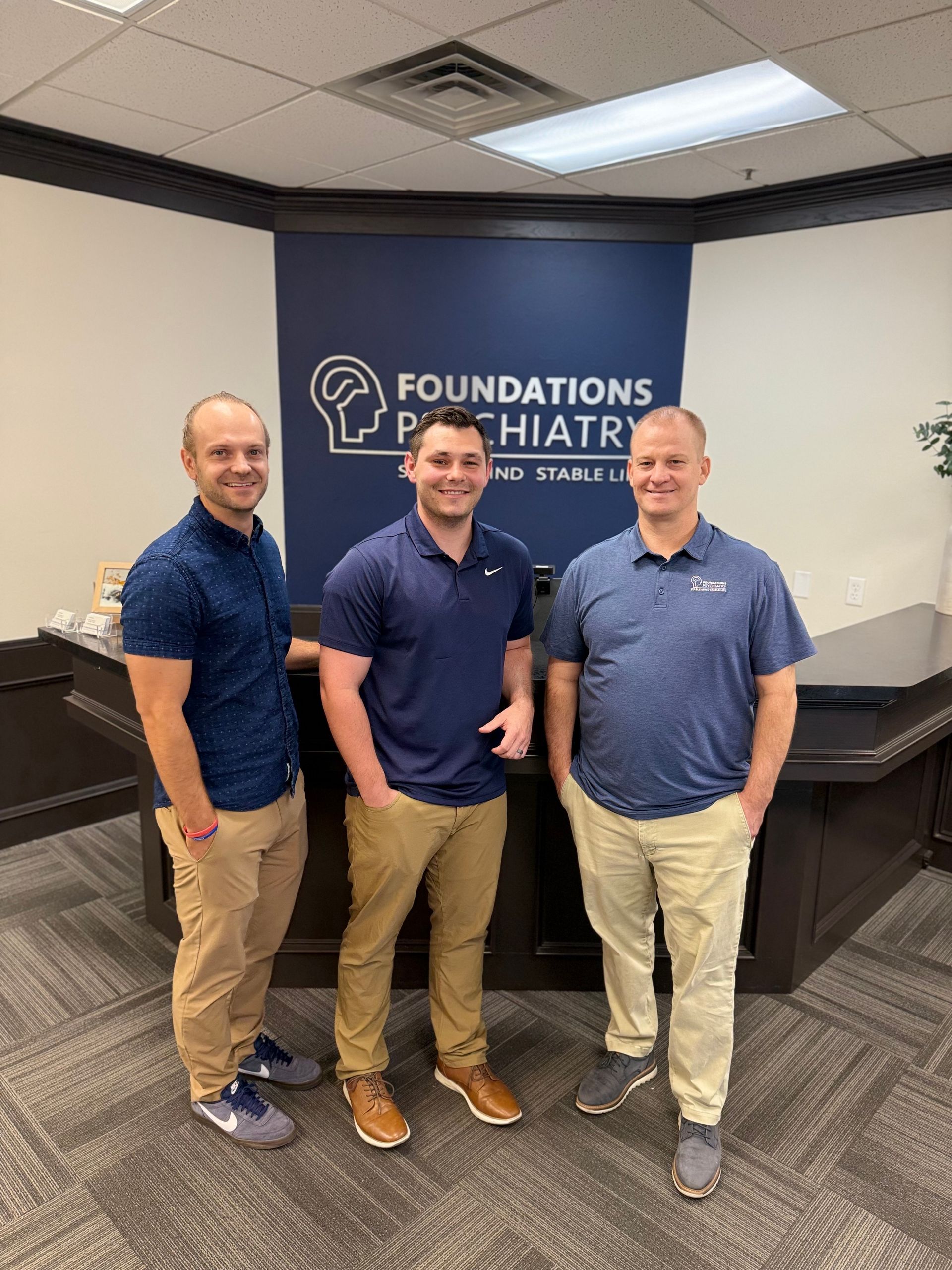 A group of people are posing for a picture in front of a red rock formation.
