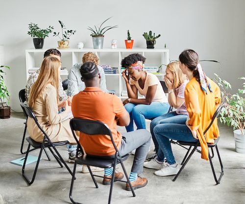 A group of people are sitting in a circle in a room.