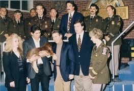 A group of people standing next to each other holding a dog.