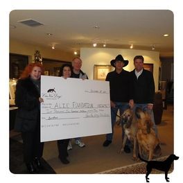 A group of people holding a large cheque that says 