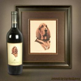 A bottle of wine next to a framed picture of a dog