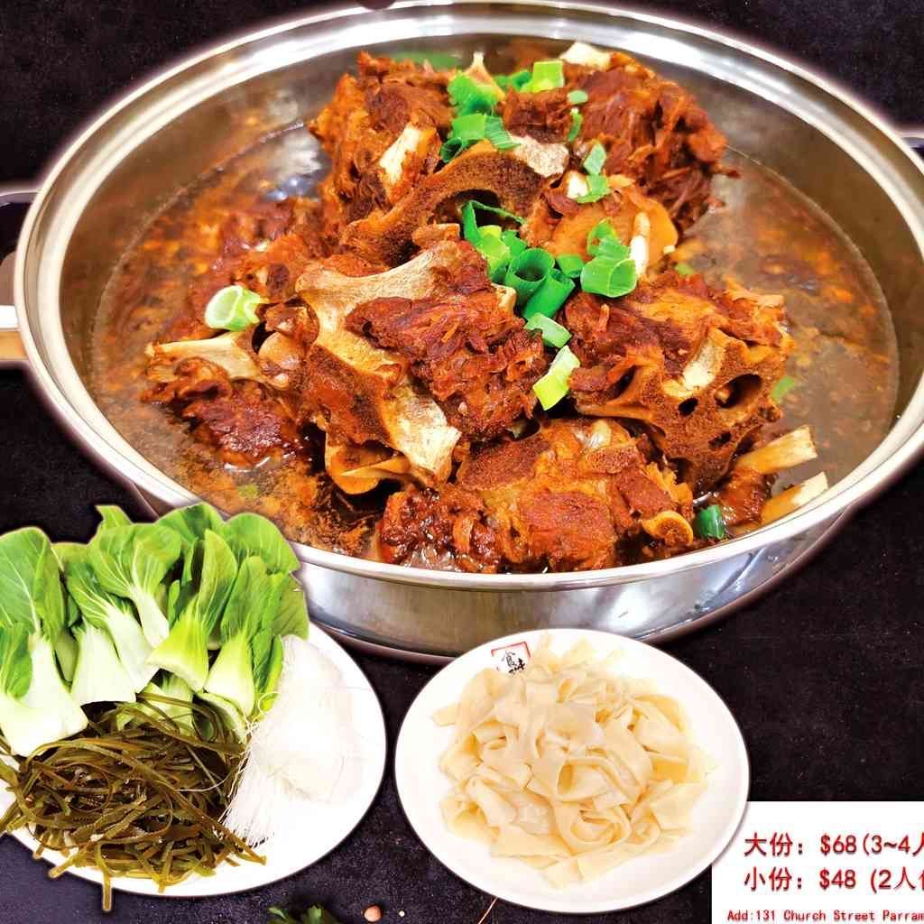 A bowl of meat and vegetables next to a plate of noodles