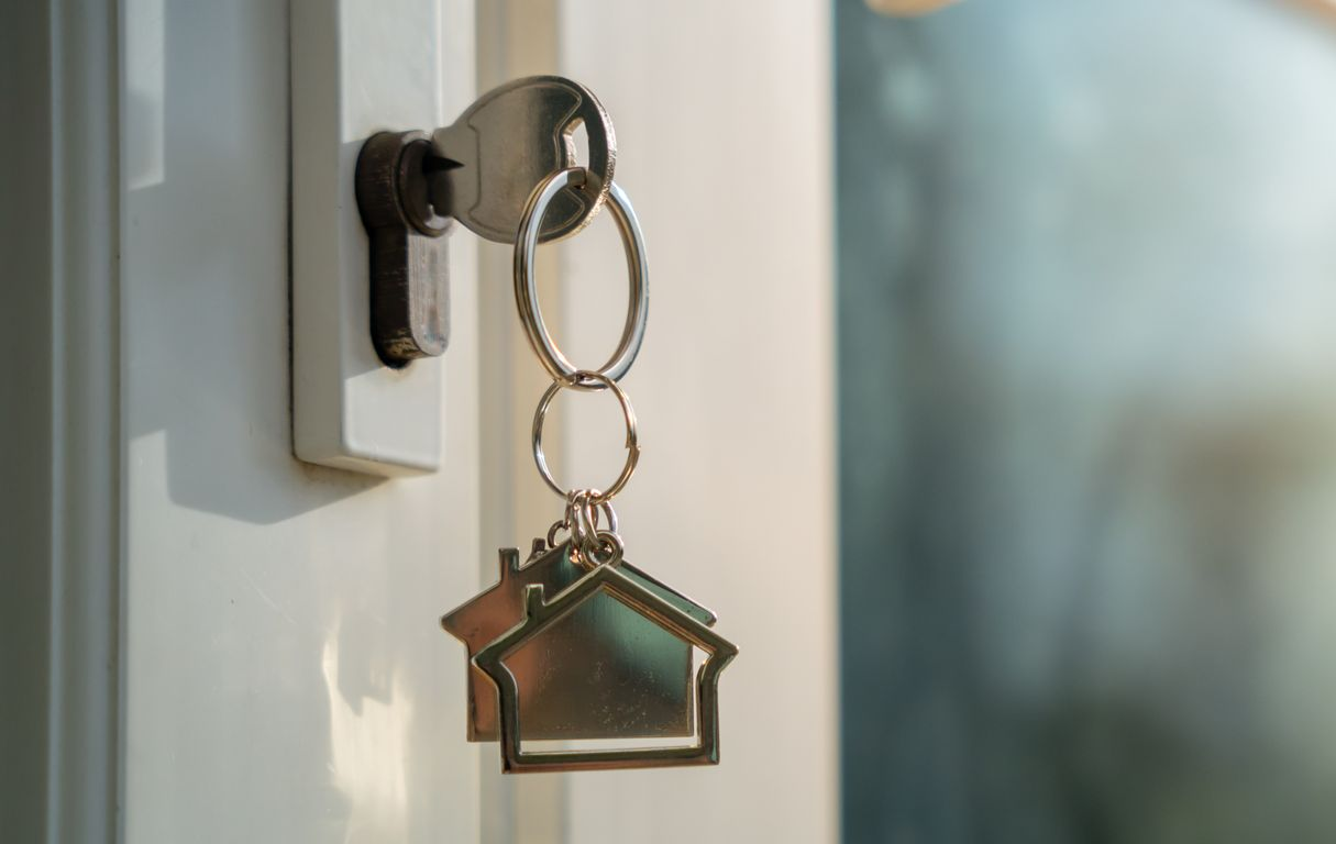 House key hanging in front door lock, symbolizing sell process and buy my house fast solution.