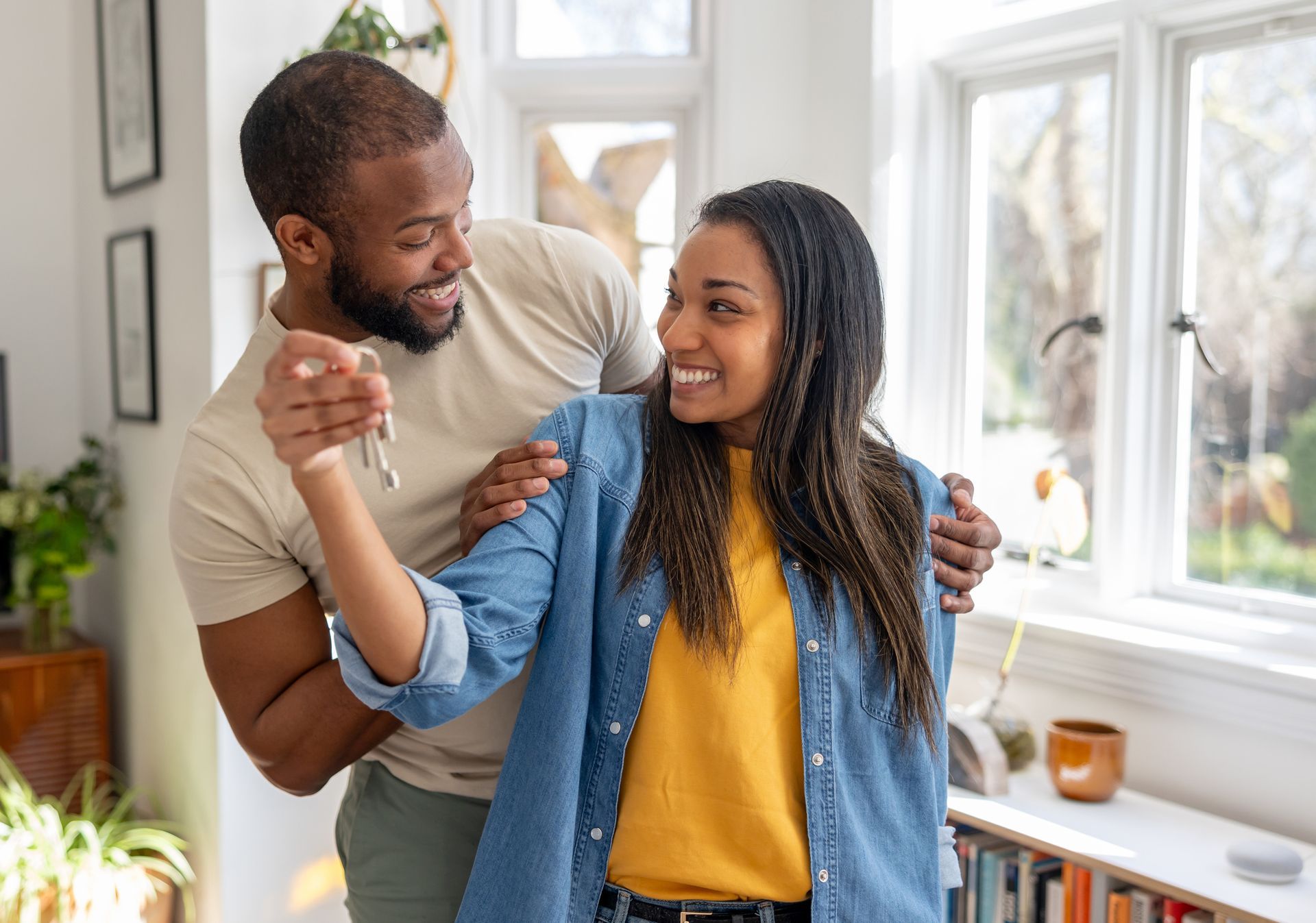 Couple looking very happy holding the keys of their new house.