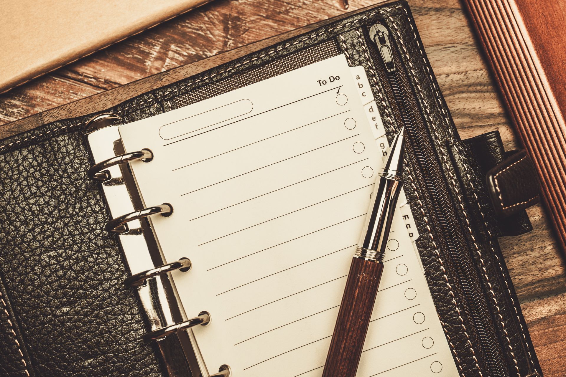 Open leather planner with lined paper and pen.