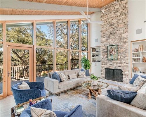 huge windows installed by Sunglass Replacement Windows and Doors in living room filled with furniture and a fireplace .