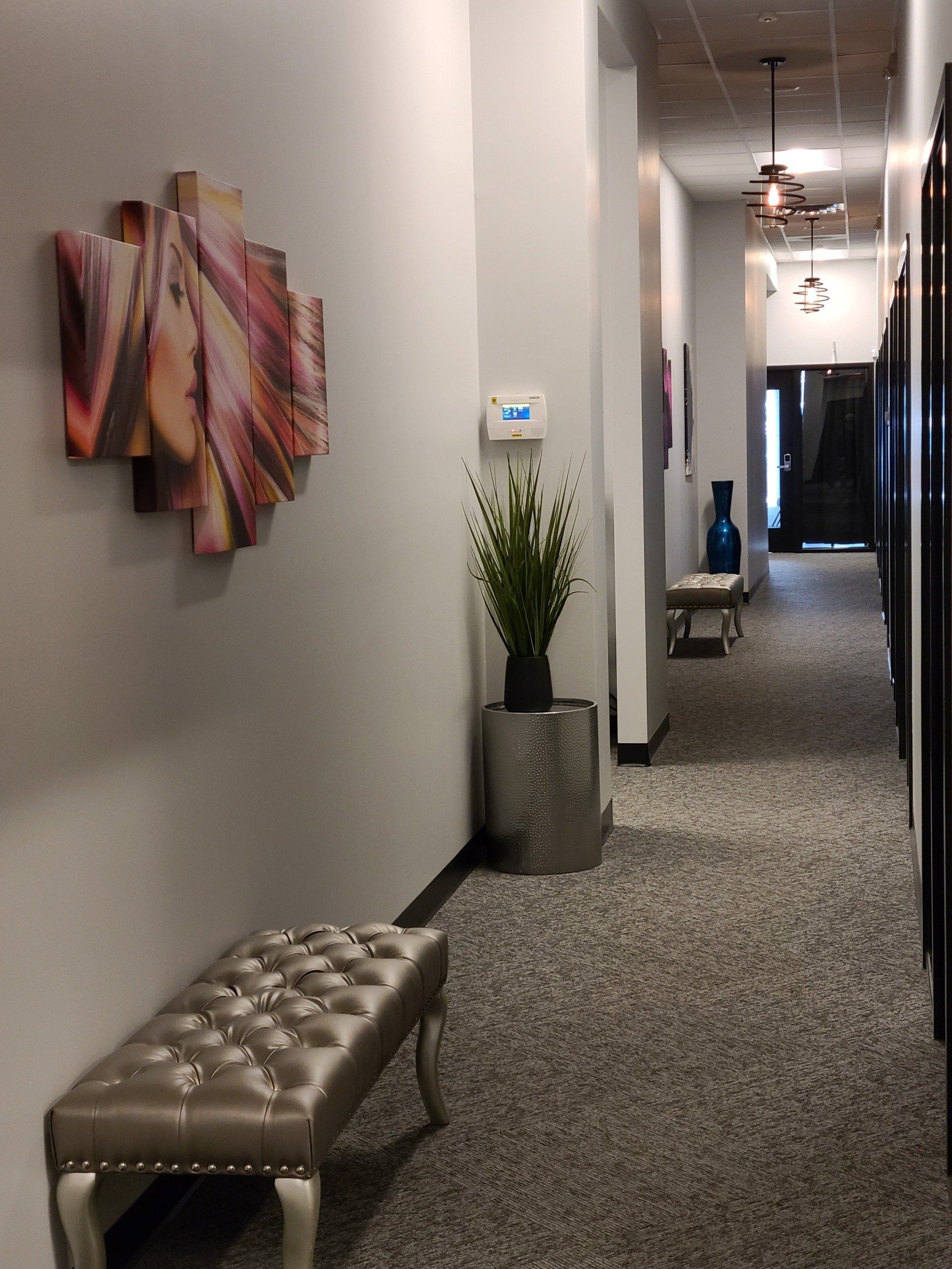 A hallway with a bench and a painting on the wall