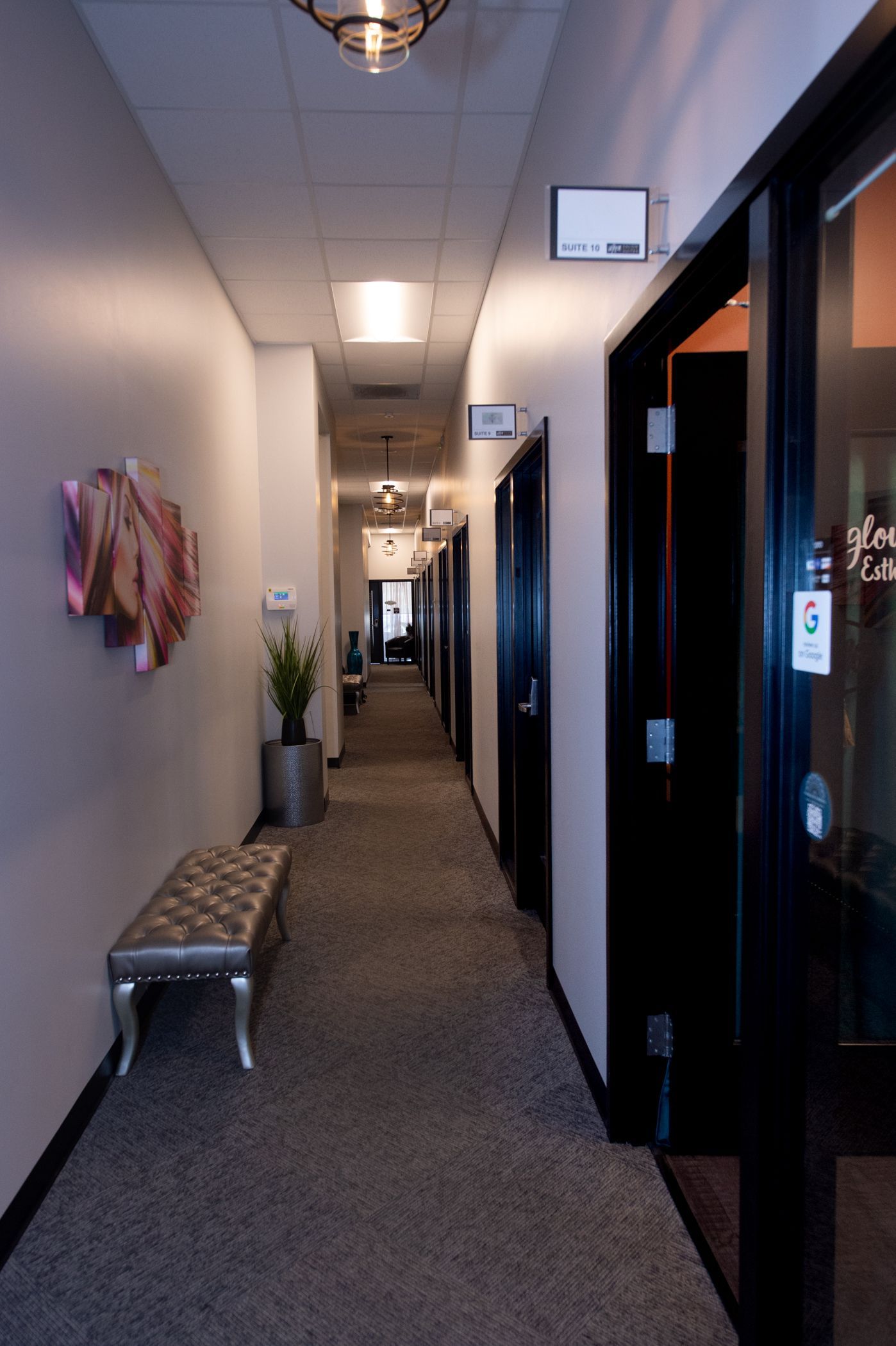 A long hallway with a bench in the middle of it