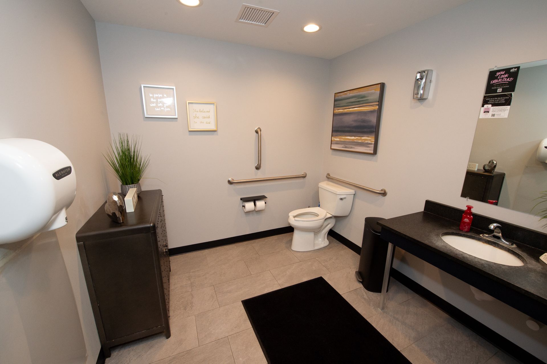 A bathroom with a toilet , sink and mirror.