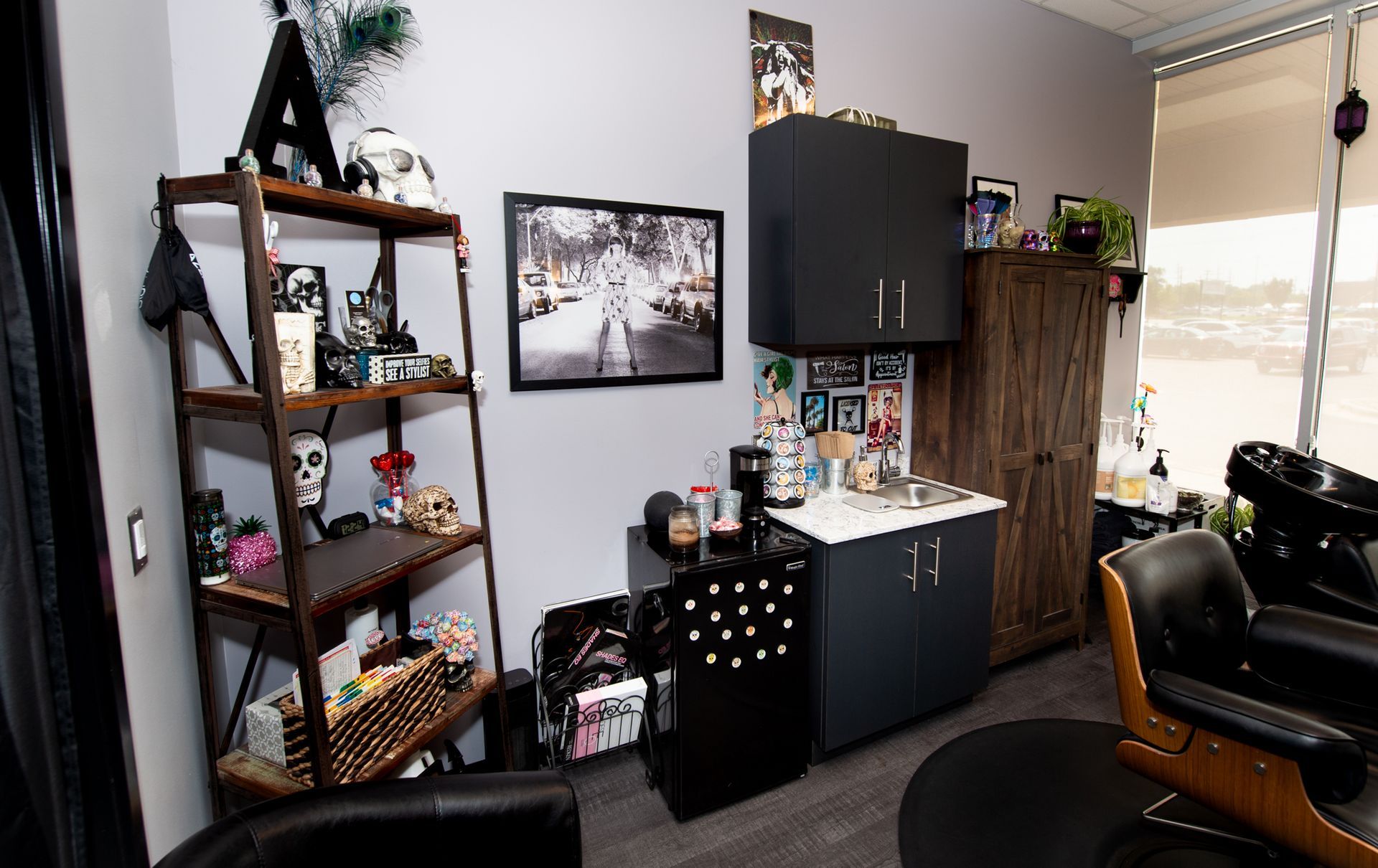 A salon with a sink , chairs , shelves and a picture on the wall.
