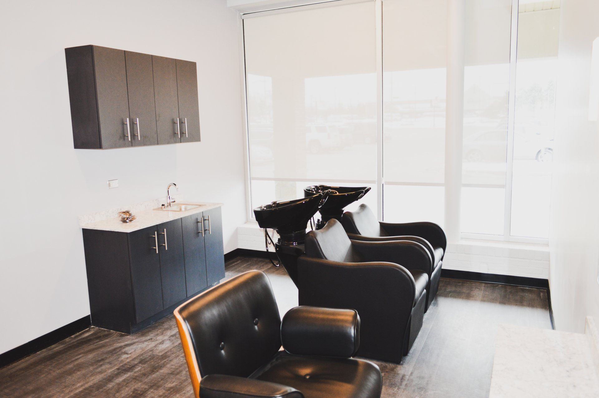 A hair salon with two chairs and a sink.