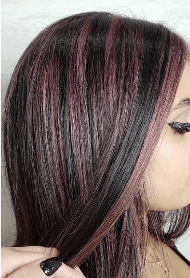 A close up of a woman 's hair with purple highlights.