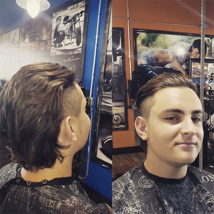 A young man is getting his hair cut in a barber shop