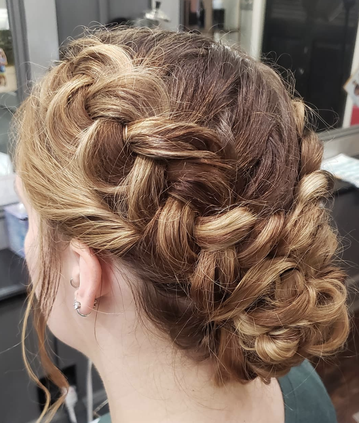 A woman is wearing her hair in a braided bun.