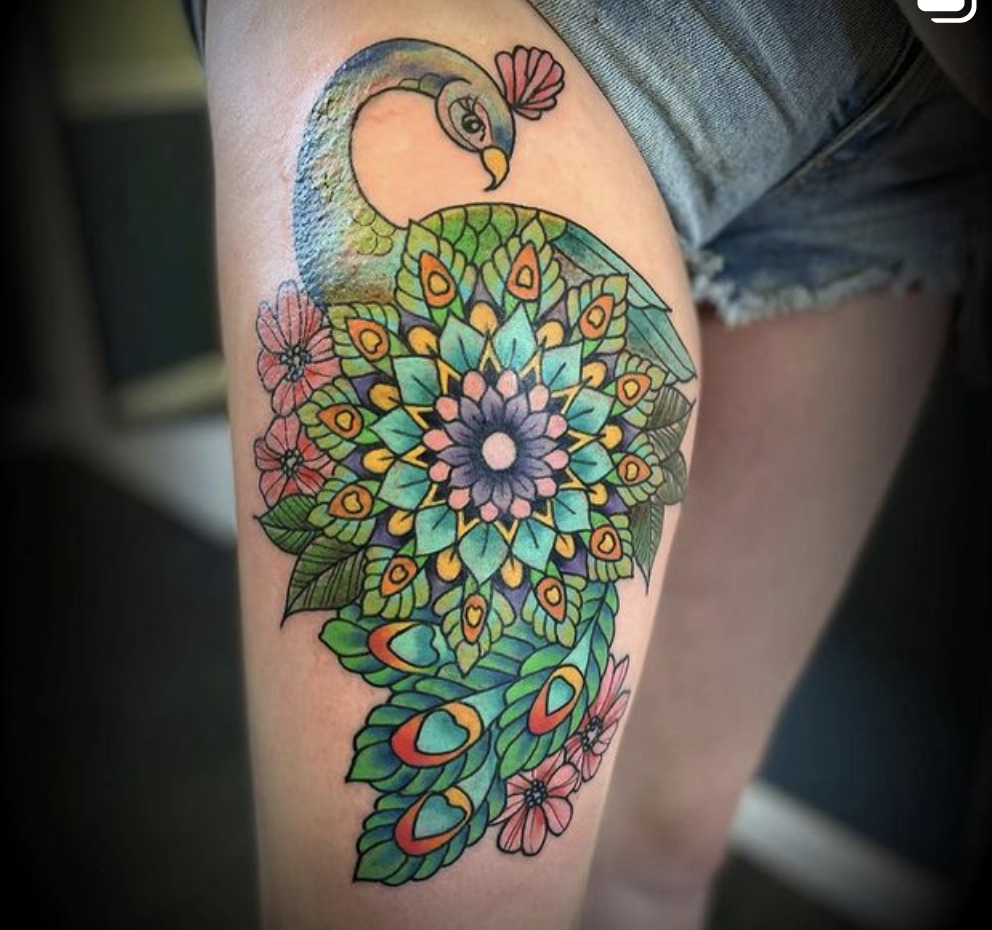 A woman has a peacock tattoo on her leg