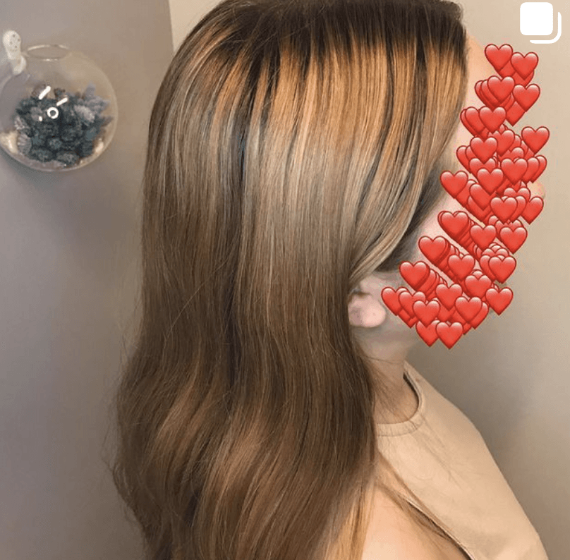 A woman with long brown hair has hearts on her face