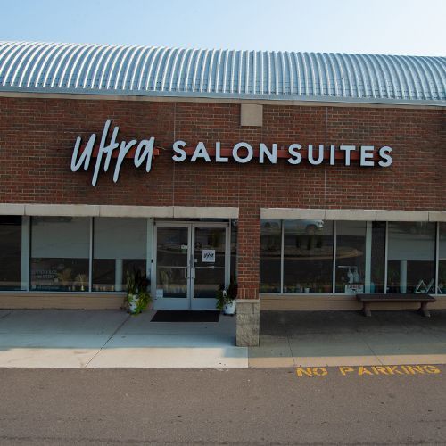 A brick building with a sign that says ultra salon suites