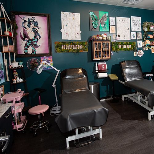 A room with a bed , chairs , shelves and a sign that says tattoo