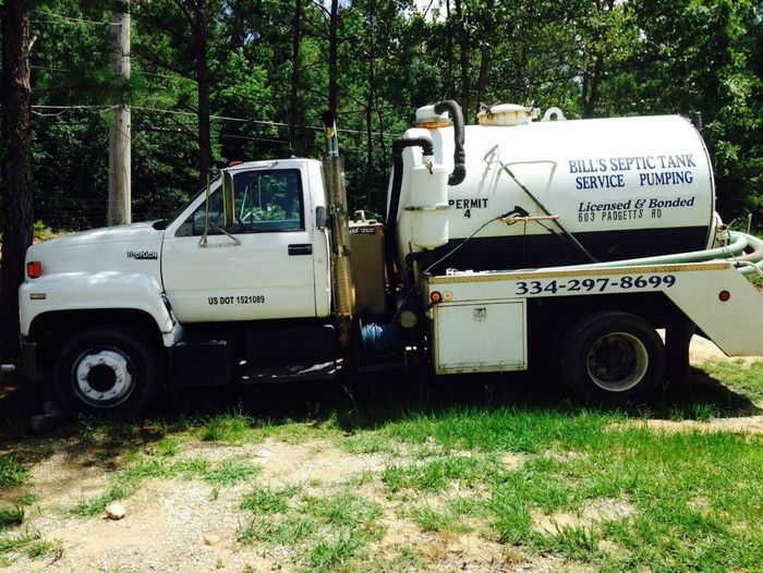 A vacuum truck with a hose attached to it on a white background.