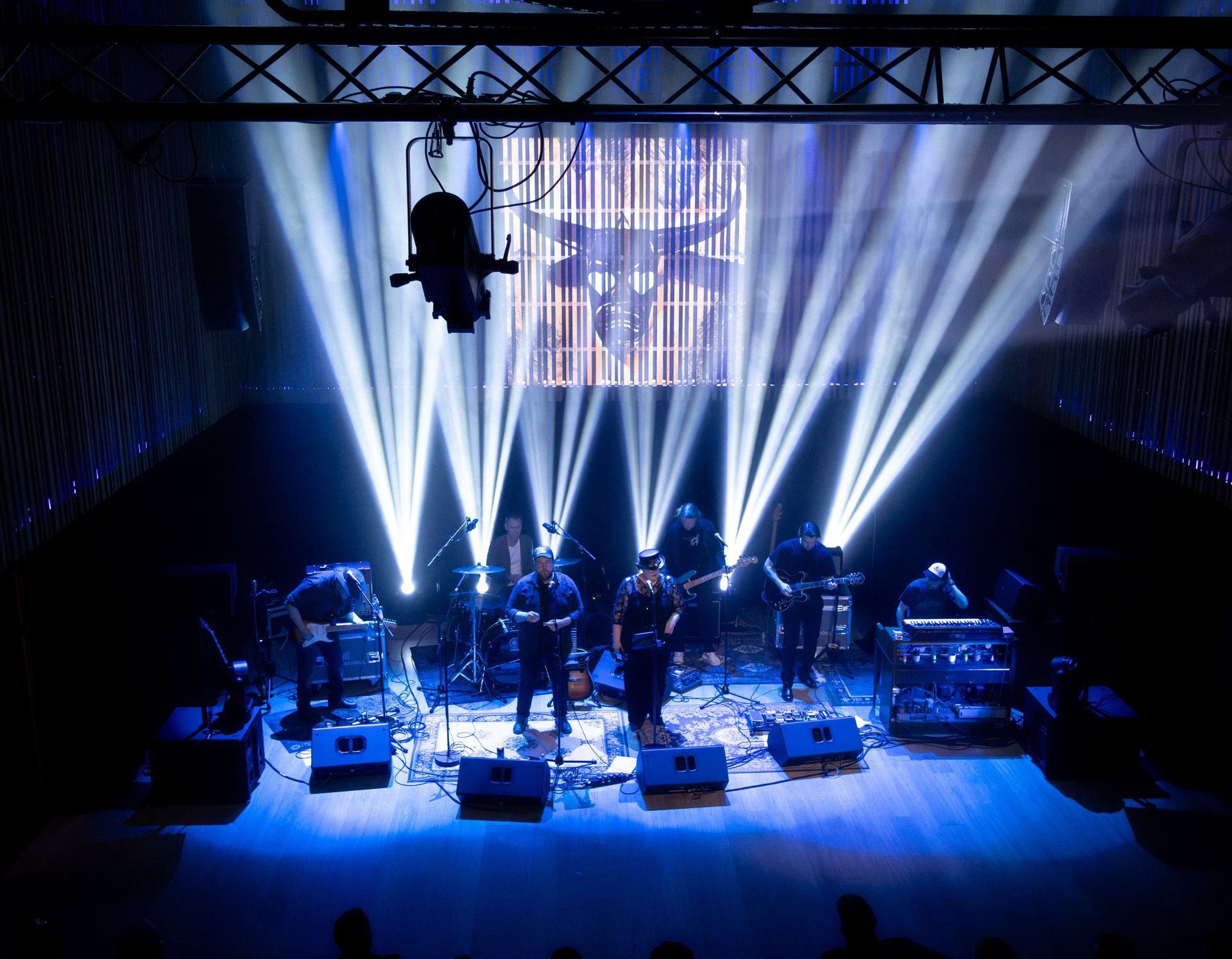 R.H.B. performing live in Berg hall at Hljómahöll with dramatic stage lighting and full instrumental setup.