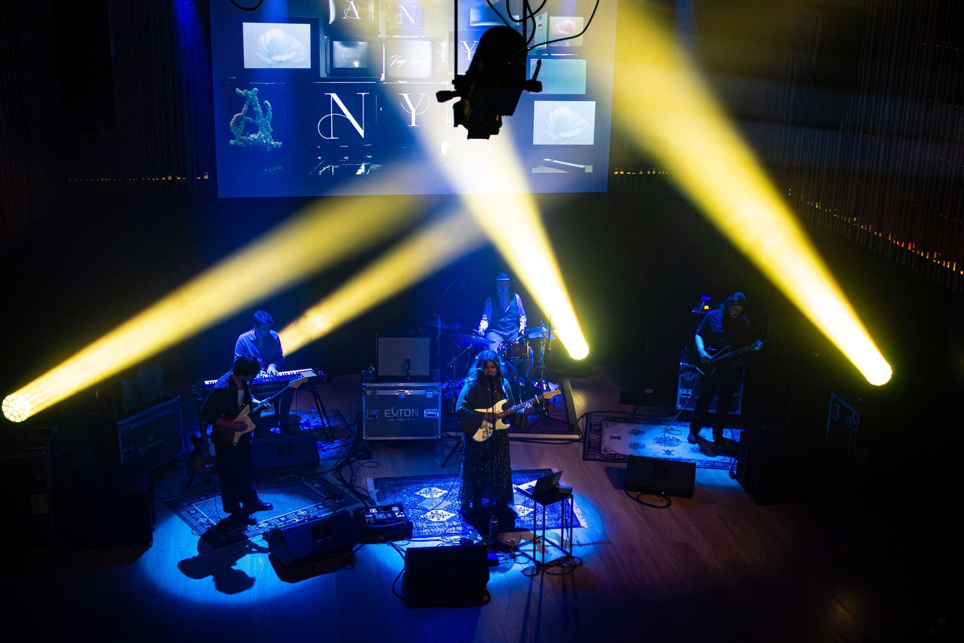 Anya Shaddock performing live in Berg hall at Hljómahöll with full band, stage lighting, and visuals on screen.