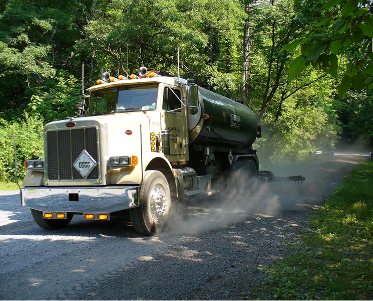 A peterbilt truck is driving down a dirt road