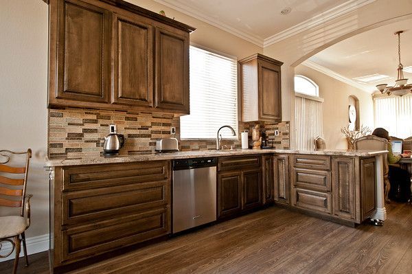 Kitchen with dark wood cabinets, stainless steel appliances, and tile backsplash.