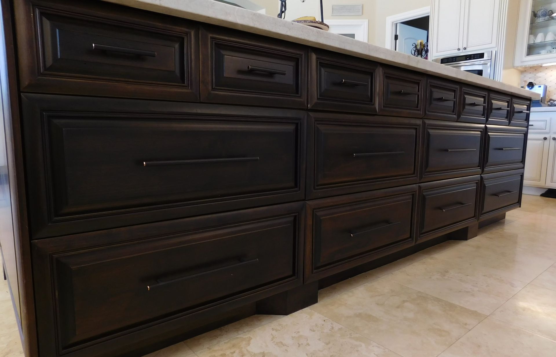 Dark wood kitchen island with multiple drawers and a light countertop.