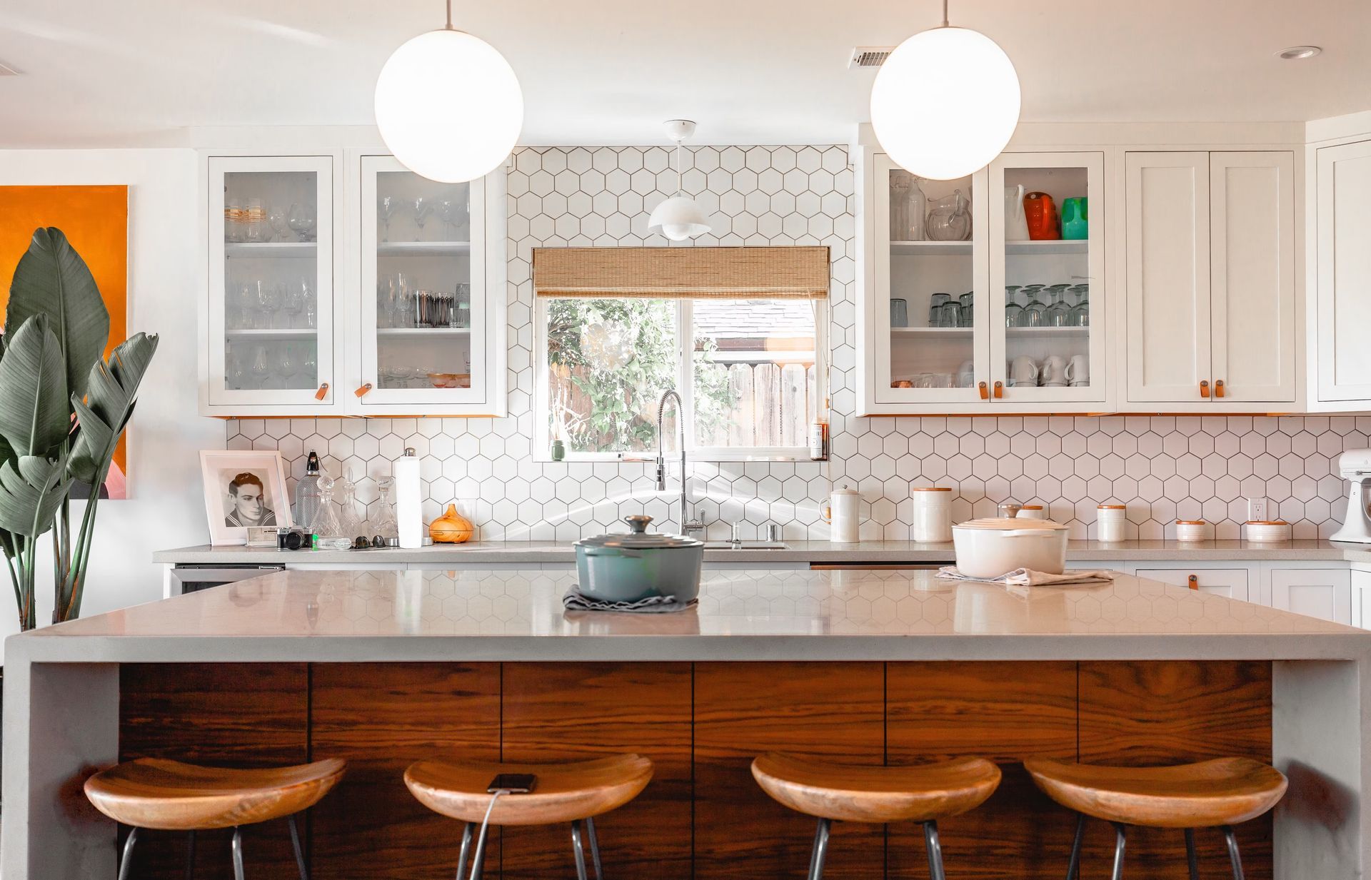 Modern kitchen with white cabinets, wood island, and pendant lights.
