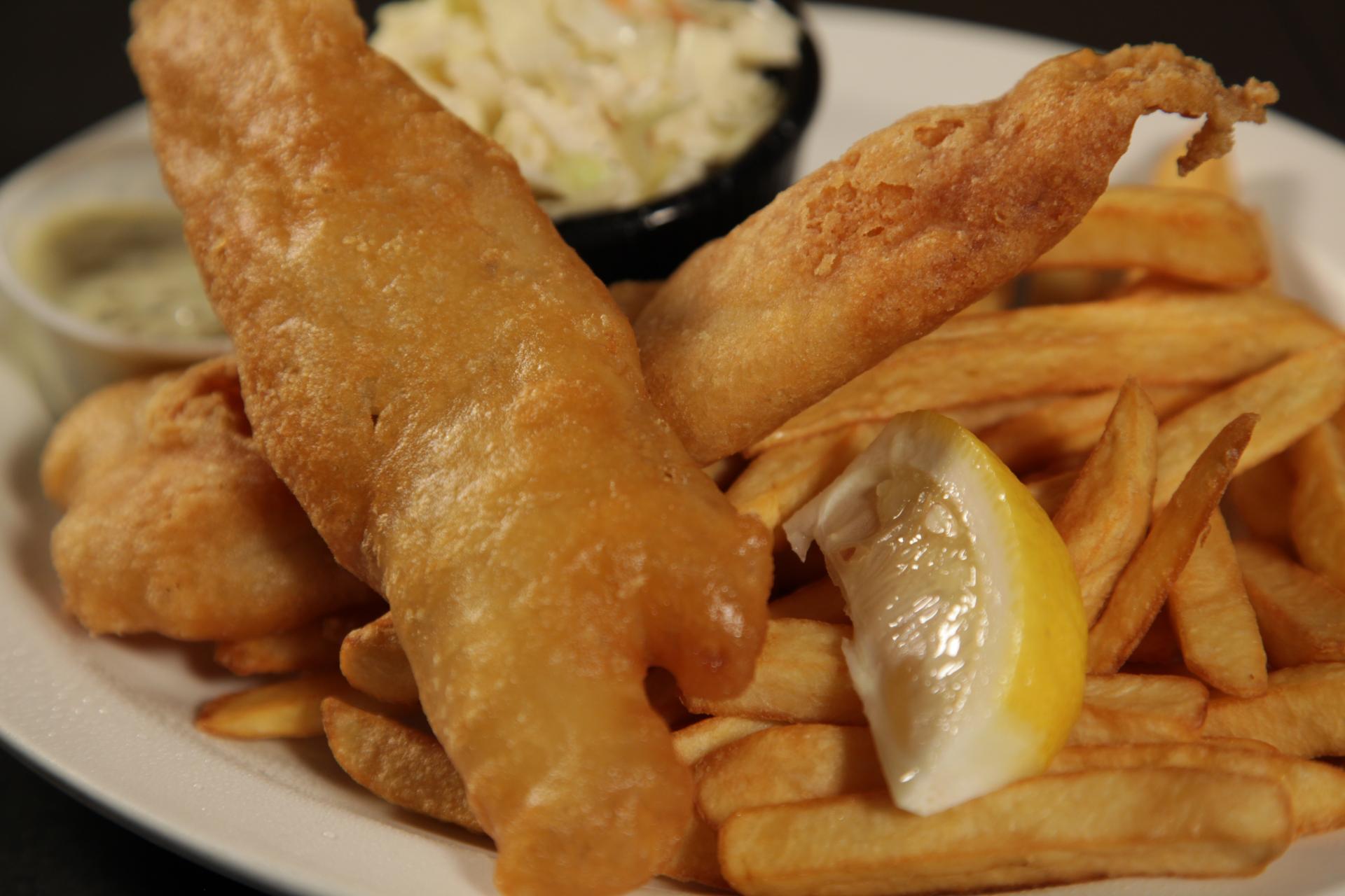 A white plate topped with fried fish and french fries