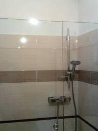 bagno con piastrelle e box doccia in vetro