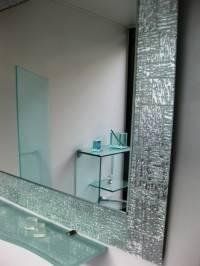 bagno con mobili in vetro e specchio